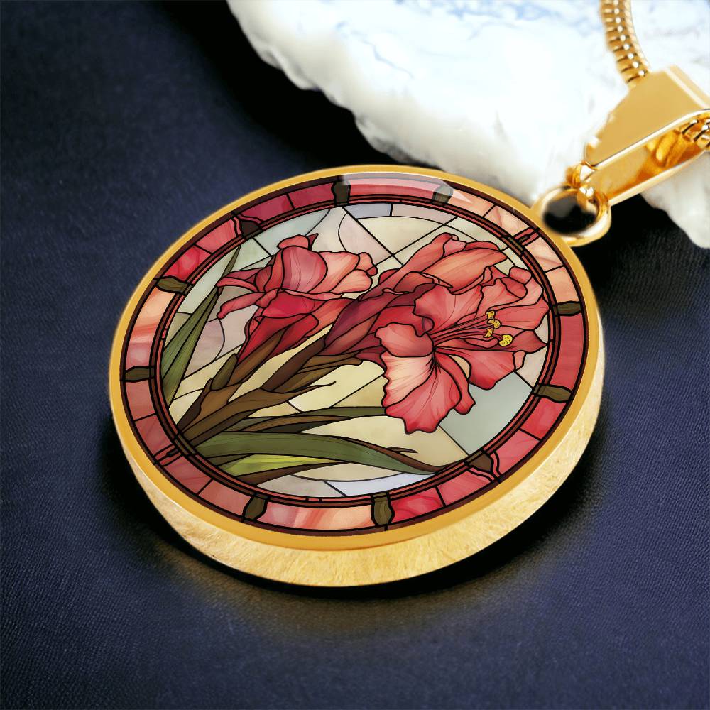 an elegant gold pendant Gladiolus Necklace. The colors are tan/green/blue/purple background, red and pink flowers, green grass, red border. This jewelry offers personalization with an engraving option for a name.