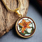 An Elegant Gold pendant necklaces features an Orange Tiger Lily, Green Grass, white background with a red and brown frame. This necklace offers personalization with an engraving option for a name.