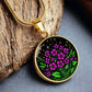 an Elegant gold pendant featuring a vivid Purple African Violet Birth Flower Necklace with green grass, gold stars set against a Black backdrop. This jewelry offers personalization with an engraving option for a name.