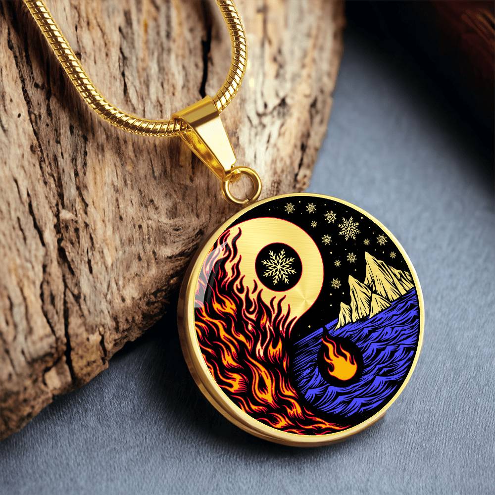 an Elegant gold pendant featuring a vivid Red/Orange Fire, Blue Water, gold snow flakes and gold Icebergs. set against a gold & Black backdrop. This jewelry offers personalization with an engraving option for a name.