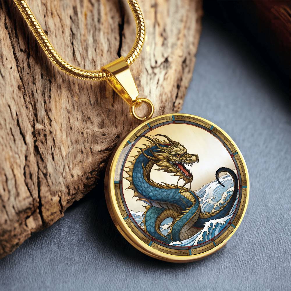 An Elegant gold pendant featuring a Water Dragon Necklace. Blue and yellow Dragon with a blue ocean, tan border and backdrop. This jewelry offers personalization with an engraving option for a name.