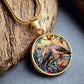 Elegant gold pendant necklace featuring two turtle doves, set against a subtle tan backdrop. This jewelry offers personalization with an engraving option for a name.