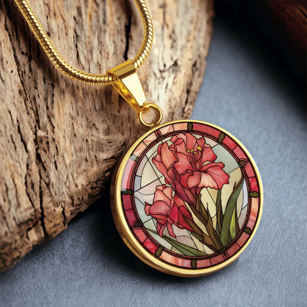 an elegant gold pendant Gladiolus Necklace. The colors are tan/green/blue/purple background, red and pink flowers, green grass, red border. This jewelry offers personalization with an engraving option for a name.