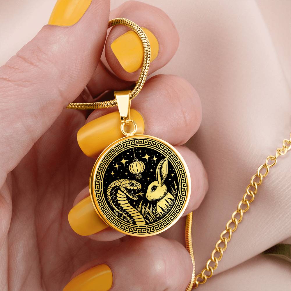 Woman holding An Elegant gold pendant featuring a Year of the Rabbit and Year of The Snake Necklace in real gold and black. This jewelry offers personalization with an engraving option for a name.