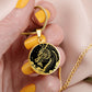 Woman holding an Elegant gold pendant Chinese Dragon necklace featuring a vivid gold dragon with stars and clouds set against a black backdrop. This jewelry offers personalization with an engraving option for a name.