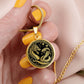 Woman holding An Elegant gold pendant featuring a Year of the Snake and Year of The Dragon Necklace in gold and black. This jewelry offers personalization with an engraving option for a name.