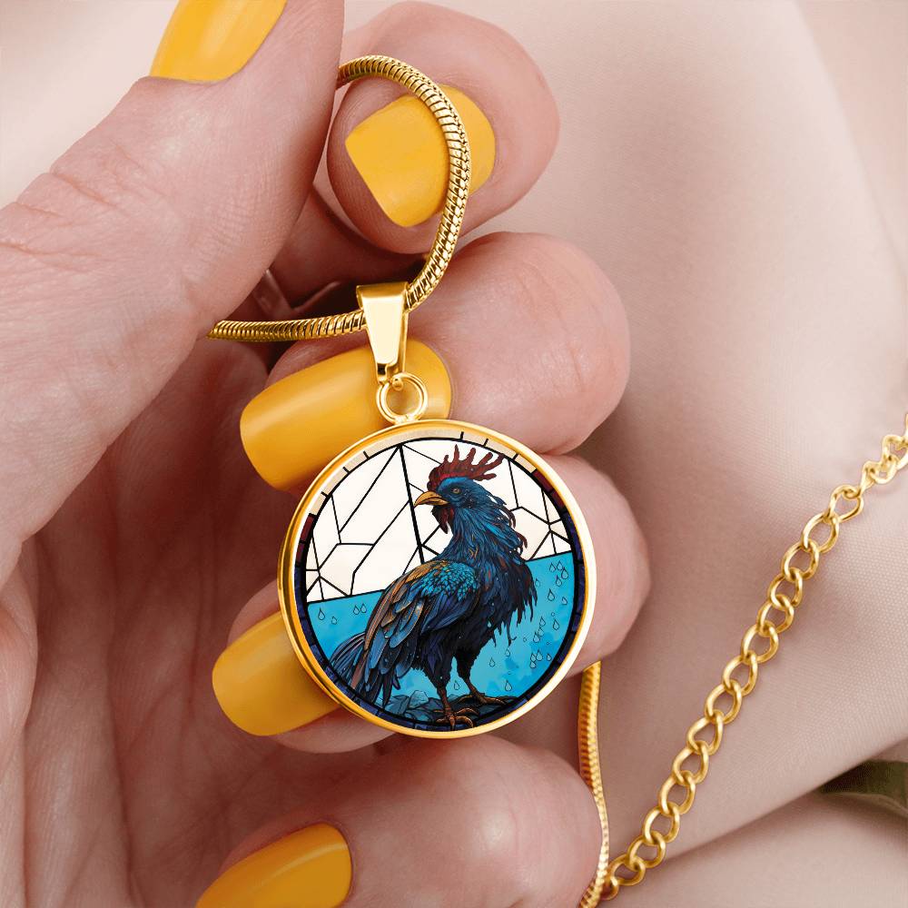 Woman holding an Elegant gold pendant featuring a Chinese Zodiac Rooster Necklace. The colors are blue, white, tan, red, yellow, brown. This jewelry offers personalization with an engraving option for a name.