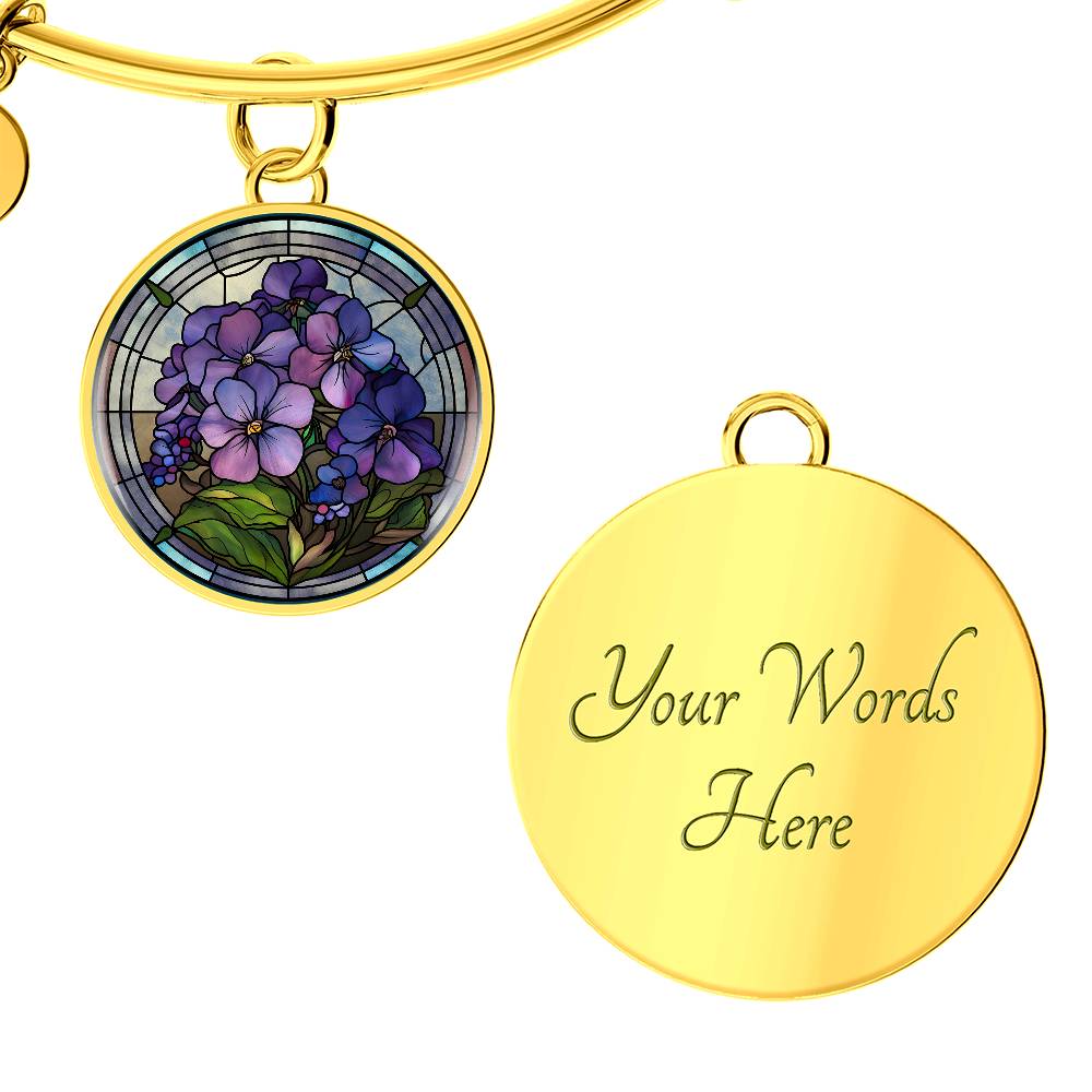 an Elegant gold pendant featuring a purple African Violet Birth Flower Bracelet, February&#39;s birth month flower, set against a blue and brown backdrop. This jewelry offers personalization with an engraving option for a name.