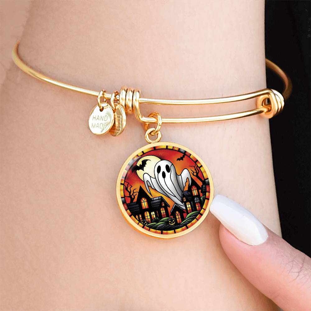 Woman wearing an elegant gold pendant Halloween Ghost Bracelet. The colors are white, black, yellow, orange and green. This jewelry offers personalization with an engraving option for a name.