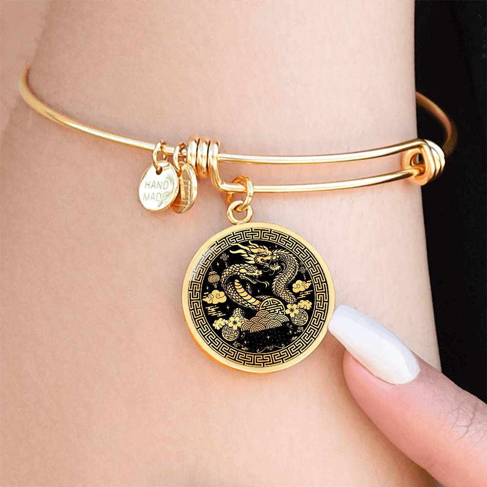 Woman wearing an Elegant gold Year of the Dragon and Snake Bracelet. The colors are gold and black. This bangle bracelet & pendant has an engraving option for a personalization.