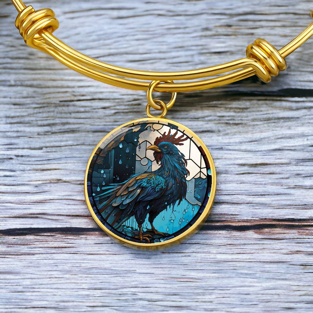 an Elegant gold pendant Rooster Bracelet, featuring a blue/red colored rooster set against a tan/blue Rain backdrop. This jewelry offers personalization with an engraving option for a name.