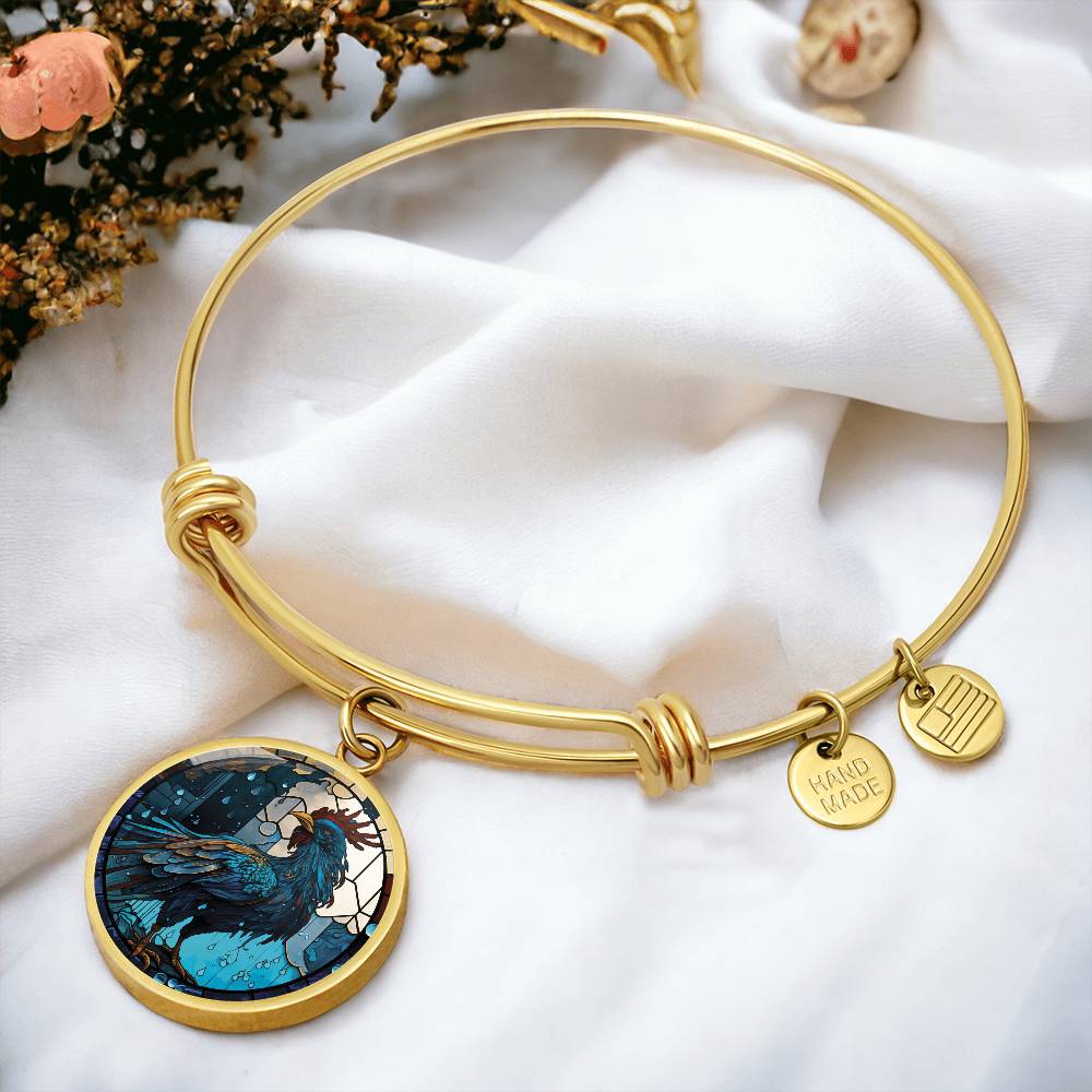 an Elegant gold pendant Rooster Bracelet, featuring a blue/red colored rooster set against a tan/blue Rain backdrop. This jewelry offers personalization with an engraving option for a name.