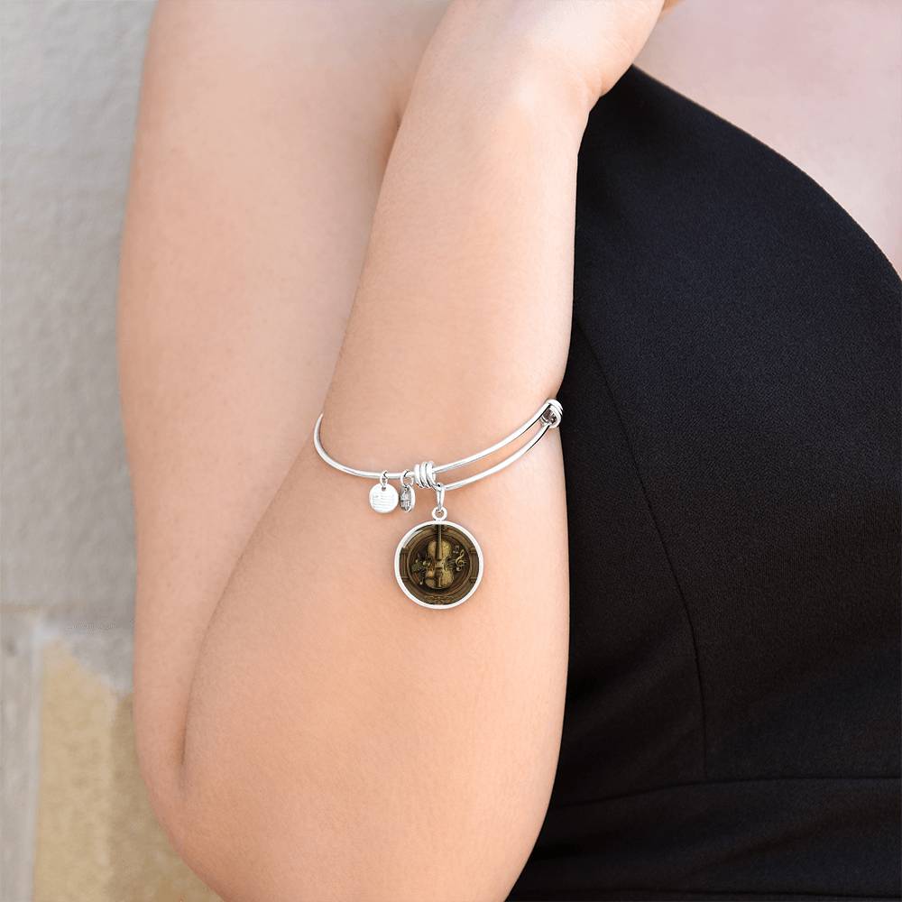 Woman wearing an elegant silver pendant Violet Bracelet. The colors are brown, black and tan. This jewelry offers personalization with an engraving option for a name.