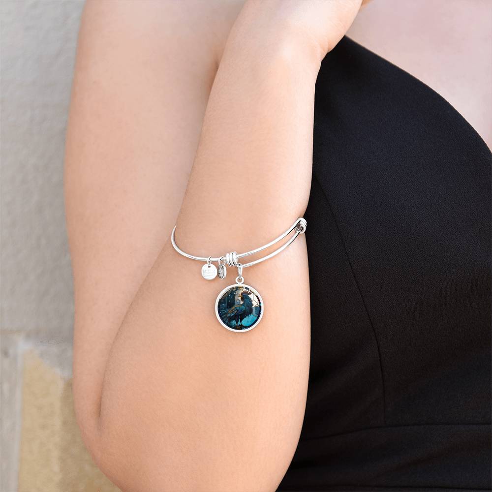 Woman wearing an Elegant silver pendant Rooster Bracelet, featuring a blue/red colored rooster set against a tan/blue Rain backdrop. This jewelry offers personalization with an engraving option for a name.