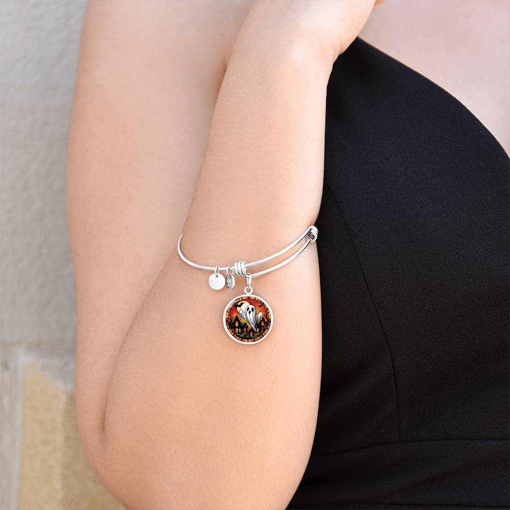 Woman wearing an elegant silver pendant Halloween Ghost Bracelet. The colors are white, black, yellow, orange and green. This jewelry offers personalization with an engraving option for a name.