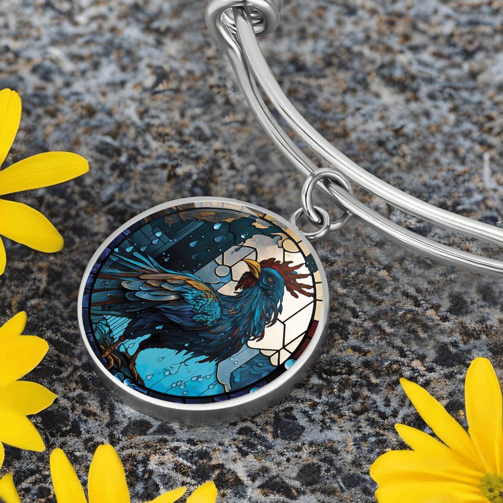 an Elegant silver pendant Rooster Bracelet, featuring a blue/red colored rooster set against a tan/blue Rain backdrop. This jewelry offers personalization with an engraving option for a name.