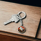 An elegant silver pendant Halloween Ghost Keychain. The colors are white, black, yellow, orange and green. This jewelry offers personalization with an engraving option for a name.