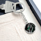 an Elegant silver pendant featuring a vivid Jade Dragon keychain set against a silver and black backdrop. This jewelry offers personalization with an engraving option for a name.