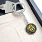 An Elegant Silver pendant Daffodil Necklace, March&#39;s birth month flower. Colors, Yellow flower, Green Grass, Brown Border, Dark Green background. This jewelry offers personalization with an engraving option for a name.