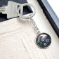 An elegant silver pendant Morning Glory Keychain, The Colors are green, purple, blue and tan. This jewelry offers personalization with an engraving option for a name.