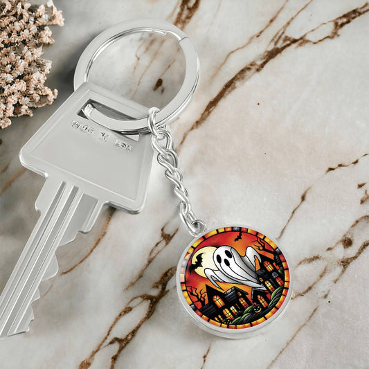 An elegant silver pendant Halloween Ghost Keychain. The colors are white, black, yellow, orange and green. This jewelry offers personalization with an engraving option for a name.