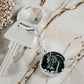 an Elegant silver pendant featuring a vivid Jade Dragon keychain set against a silver and black backdrop. This jewelry offers personalization with an engraving option for a name.