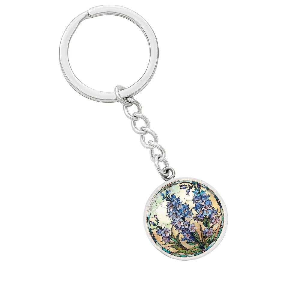 An elegant silver pendant Larkspur Flower Keychain. The colors are blue, purple, green and tan. This jewelry offers personalization with an engraving option for a name.