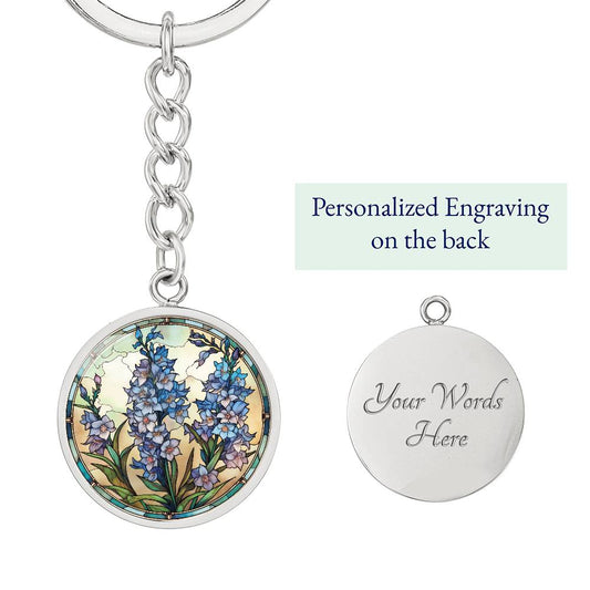 An elegant silver pendant Larkspur Flower Keychain. The colors are blue, purple, green and tan. This jewelry offers personalization with an engraving option for a name.