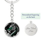 an Elegant silver pendant featuring a vivid Jade Dragon keychain set against a silver and black backdrop. This jewelry offers personalization with an engraving option for a name.
