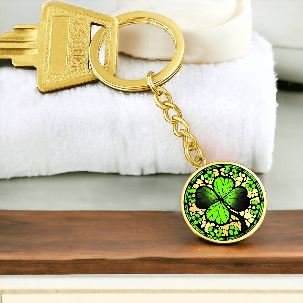 Elegant Gold pendant featuring a vivid Four Leaf Clover Keychain, set against a gold backdrop. This jewelry offers personalization with an engraving option for a name