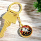 An elegant gold pendant Halloween Ghost Keychain. The colors are white, black, yellow, orange and green. This jewelry offers personalization with an engraving option for a name.