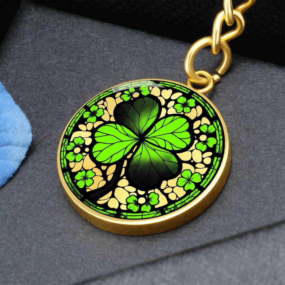 Elegant Gold pendant featuring a vivid Four Leaf Clover Keychain, set against a gold backdrop. This jewelry offers personalization with an engraving option for a name